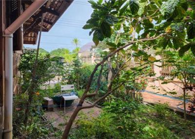 Thai waterfront home with serene shaded surroundings.