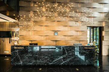 Modern hotel lobby with wooden wall panels and marble reception desk