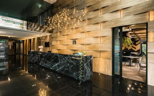 Modern hotel lobby with wooden wall panels and marble reception desk