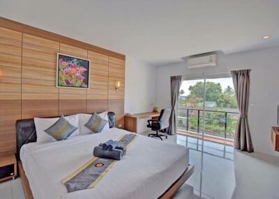 Spacious bedroom with modern design, large bed, and a beautiful view