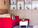Cozy living room interior with red sofa and decorative shelves