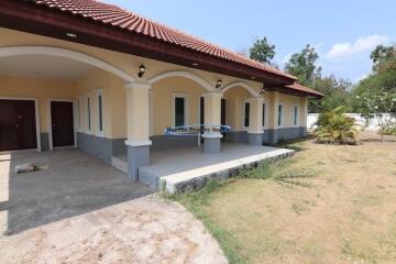 Spacious front porch of a house with a broad roof and multiple columns