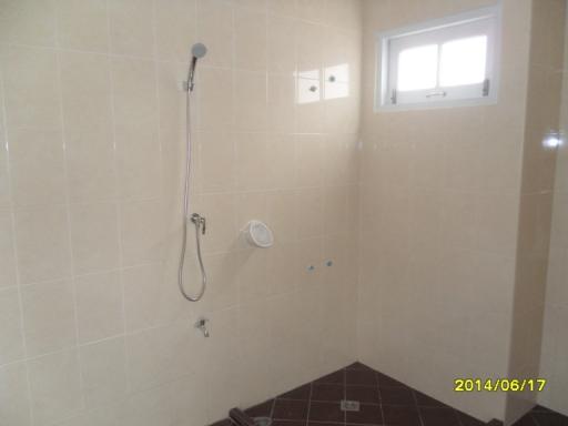 Modern bathroom with beige wall tiles and brown floor