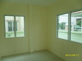 Empty bedroom with two windows and tiled flooring