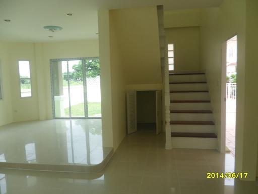 Spacious empty living area with staircase and natural light