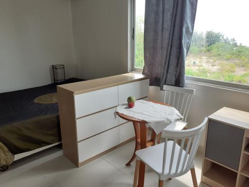 Cozy bedroom with a window view, a small dining area, and a dresser