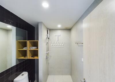 Modern bathroom with walk-in shower and wooden storage shelf