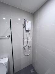 Shower area in a tiled bathroom with an electric water heater