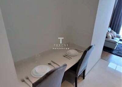 Minimalist dining area with two chairs and a table setting for two.