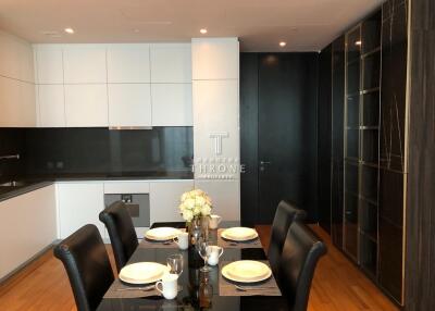 Modern dining area with a set table, adjacent to a stylish kitchen