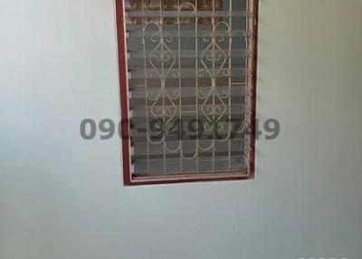 Window with security bars on a tiled wall in an unidentified room