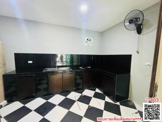 Modern kitchen with black cabinetry and checkered floor