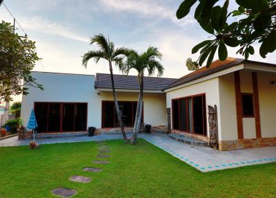 Suburban house with a well-maintained lawn and palm trees