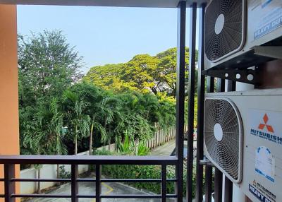 Well-ventilated balcony with a view of greenery and air conditioning units