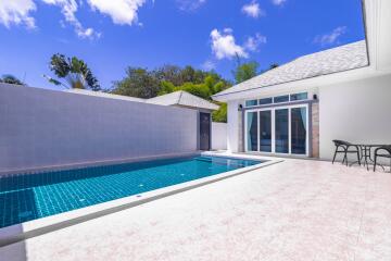 Inviting outdoor swimming pool with adjacent patio and sliding glass doors to the residence
