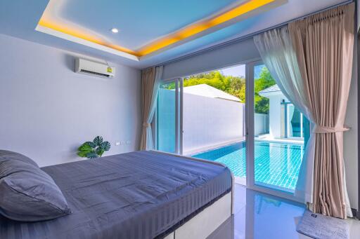 Modern bedroom with direct pool access and ambient lighting