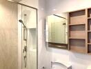 Modern bathroom with shower area, large mirror, and shelving