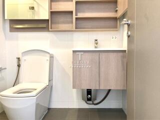 Modern bathroom with wooden cabinetry and toilet
