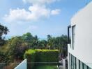 Modern building with glass walls overlooking a pool and lush greenery