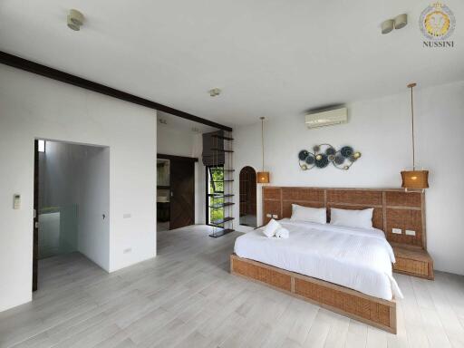 Spacious modern bedroom with double bed and open shelving