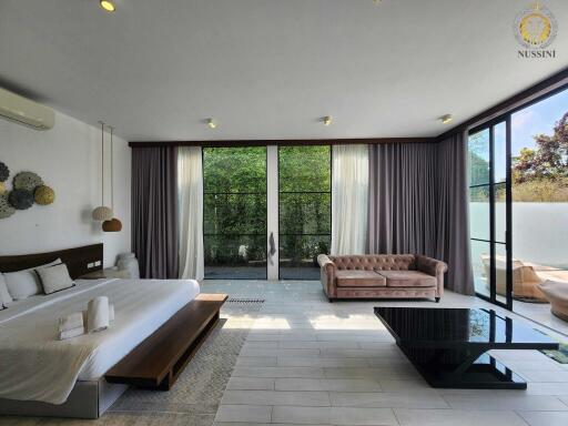 Spacious bedroom with large windows and a sitting area