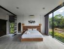 Modern spacious bedroom with large windows and nature view