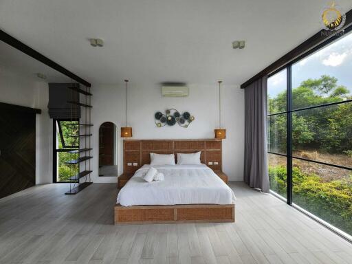 Modern spacious bedroom with large windows and nature view