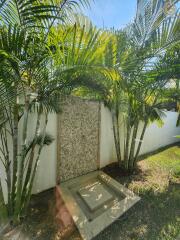 Outdoor shower area surrounded by palm trees