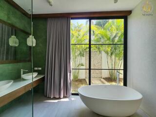 Modern bathroom with large window and standalone tub