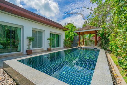 Inviting outdoor swimming pool with adjacent covered patio and green landscaping