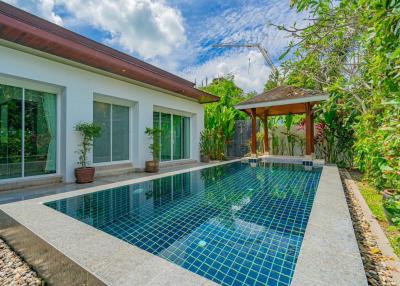 Inviting outdoor swimming pool with adjacent covered patio and green landscaping