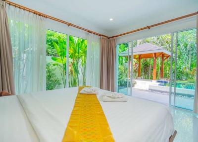 Bright bedroom with lush garden view and pool access