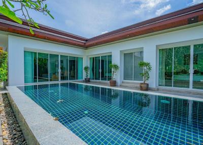 Luxurious home exterior with a large swimming pool and glass doors leading to the interior