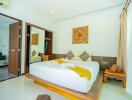 Bright and spacious bedroom with a comfortable double bed, wooden accents, and modern amenities
