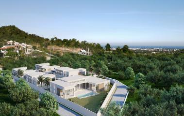 Modern residential buildings with balconies in a green landscaped area overlooking the sea