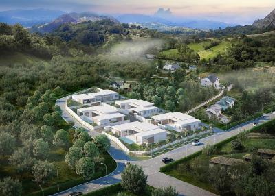 Aerial view of a modern housing complex amid a natural landscape with mountainous backdrop