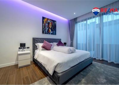 Modern bedroom with comfortable bedding, ambient lighting, and hardwood floors