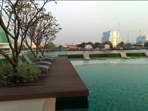 Outdoor swimming pool with lounge chairs and city view