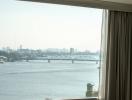 View from a high-rise building window overlooking a river and bridge