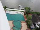 Aerial view of an outdoor swimming pool next to a river