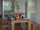 Modern dining room with table set for dinner and open-concept kitchen in the background