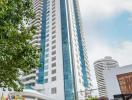 Modern high-rise condominium building with a landscaped entrance