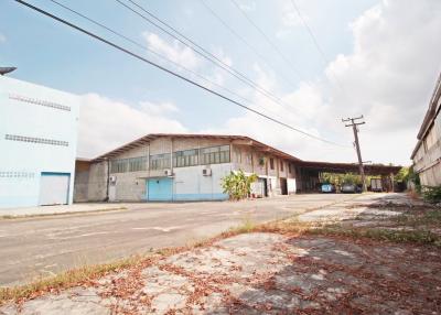 Wide angle view of a large industrial building exterior with multiple entrances