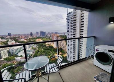 High-rise apartment balcony with city view and outdoor furniture