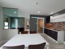 Modern kitchen with white dining table and adjacent living area