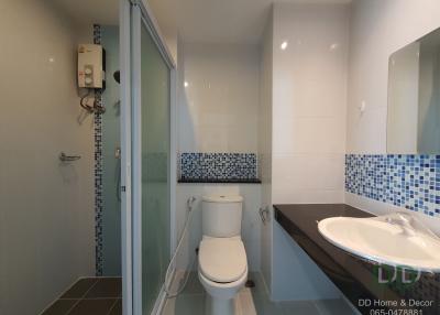Modern bathroom interior with glass shower, white toilet, and sink