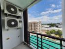 Spacious balcony with air conditioning units and a city view