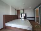 Spacious unfurnished bedroom with large window and wooden wardrobe