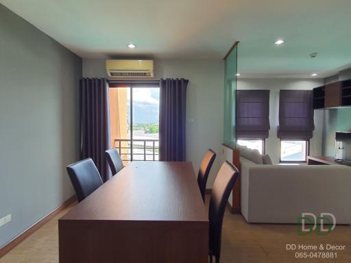 Modern combined living and dining area with balcony access, ample natural light, and open floor plan