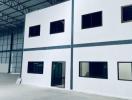 Spacious industrial warehouse interior with white office section